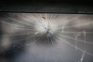 Detail view of a broken window cracked in spider web shape