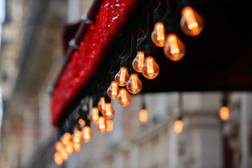 A lot of decorative vintage garland light bulbs in front of a pub restaurant terrace