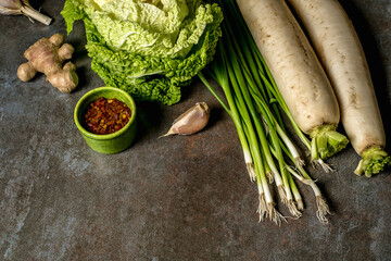 Ingredients for kimchi. Fresh vegetables, traditional Korean food in top view on wooden table copy space.