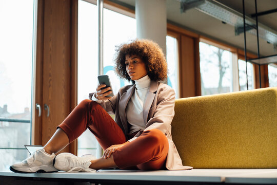 Businesswoman text messaging on mobile phone at work place
