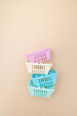 Colored empty shopping baskets on a beige background. Minimalism. Sales, shopping, prices concept