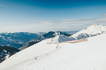 People on snowy mountain skiing at ski resort on sunny day
