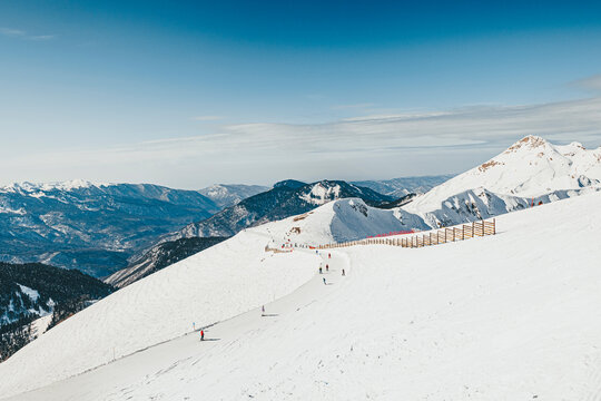 People on snowy mountain skiing at ski resort on sunny day