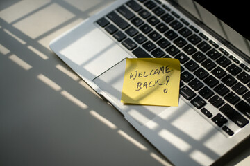 Message, Welcome back on top of computer laptop on office desk. Back to office or work concept.