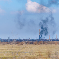 Smoke from a fire in the distance behind the field