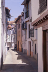 Fototapeta na wymiar Calle estrecha y tradicional con sus casas con fachadas encaladas en Hervás, Cáceres, Extremadura, España.