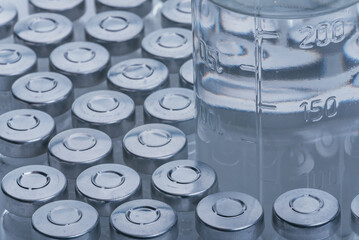 Glass medical ampoule vial for injection. Medicine is dry white drug penicillin powder or liquid with of aqueous solution in ampulla. Close up. Bottles ampule with aluminum cap on backgrounds gray.