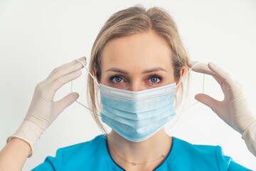 The proper way to put on and remove protective surgical mask demonstrated by young female doctor....