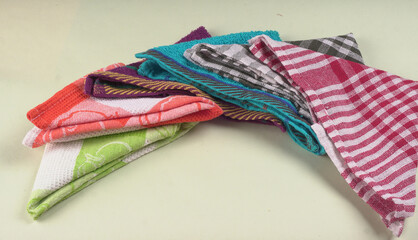 Folded kitchen textile towels of different colors, Household cleaning cloth. Closeup of cleaning rag isolated on a white background.