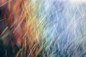 Abstract raindrops nature background. Rain on long exposure. Rain drops motion. Trails of falling raindrops and rainbow colors