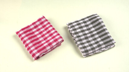 Folded kitchen textile towels of different colors, Household cleaning cloth. Closeup of cleaning rag isolated on a white background.

