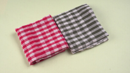 Folded kitchen textile towels of different colors, Household cleaning cloth. Closeup of cleaning rag isolated on a white background.
