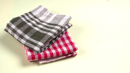 Folded kitchen textile towels of different colors, Household cleaning cloth. Closeup of cleaning rag isolated on a white background.
