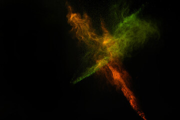Fototapeta premium Freeze motion of colorful dust explosion on black background for Happy Holi