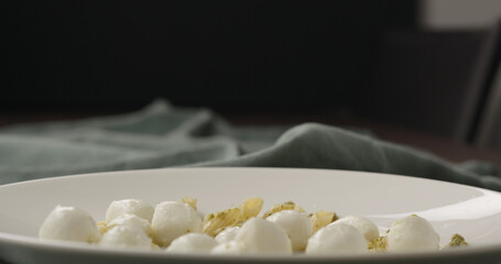 mozzarella balls on penne in white bowl