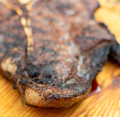 corte de res  T- bone.

T bone 

corte en el asador 

corte al carbón

manos cortando t- bone sobre tabla de madera. 