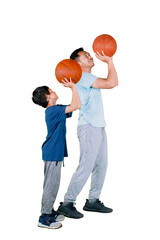 Father teaching son to shoot basketball on studio