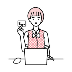 デスクで座ってPCを使いながらクレジットカードを手に持っている事務員制服の女性