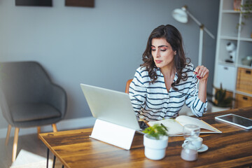 Portrait of a business woman at home with a laptop on the table. 30-year-old girl connected online. The concept of teleworking