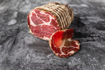 Capocollo of martina franca on marble table typical from apulia south italy. Italian salami