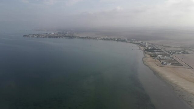 Aerial: Hazy chala desert flats surround coastal Paracas, Peru