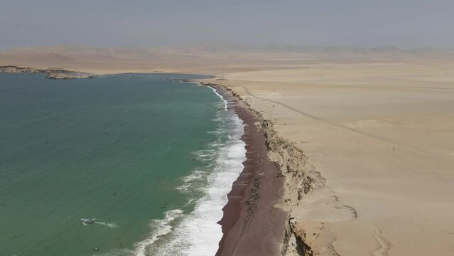 Aerial flight where Pacific ocean meets featureless desert in Peru