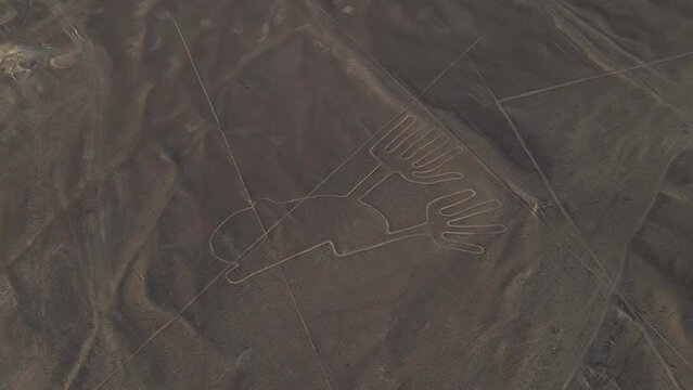 Aerial tilt view of ancient Nazca geoglyph called Hands, Peru desert