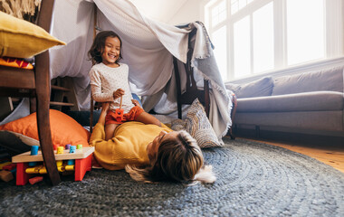 Obraz na płótnie Canvas Happy little girl having fun with her mom during playtime