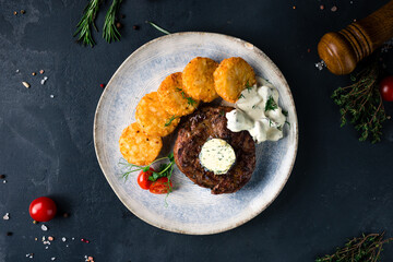 Medium rare grilled beef steak on black background with French fries