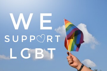 Human hands holding rainbow flags with texts 'We support lgbt', concept for lgbt celebrations in pride month, June, every year, everywhere around the world.