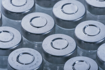 Glass medical ampoule vial for injection. Medicine is dry white drug penicillin powder or liquid with of aqueous solution in ampulla. Close up. Bottles ampule with aluminum cap on backgrounds gray.