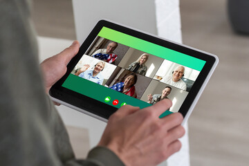 Fototapeta premium Remote Work Communication. Businesswoman Holding Tablet Having Online Meeting With Group Of Coworkers Making Video Call Via Computer Sitting In Modern Office. Selective Focus, Cropped