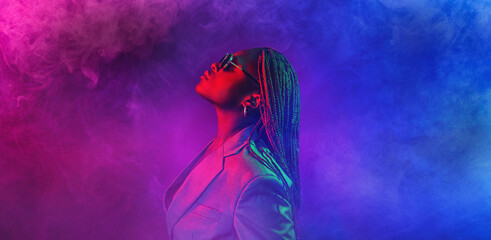 colorful neon filtered shot of a beautiful young african woman posing in the studio