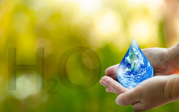 World Water Day Concept. Hand holding water droplets. Environmental protection, Earth energy-saving, Nature conservation, Blurred background.Elements of this image furnished by NASA
