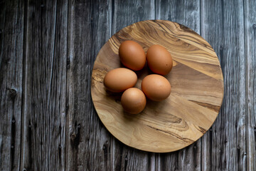 eggs on a wooden plate, copy space, rustic background