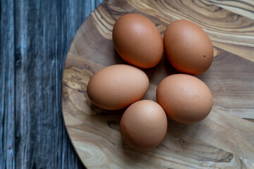 Eggs on a wooden plate, rustic background