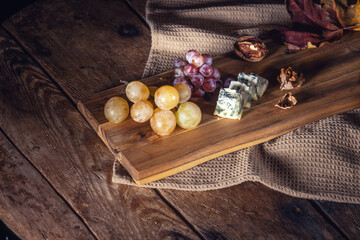 Top view of grape and cheese on wooden table