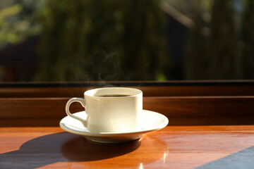 Cup of tea stands on wooden windowsill