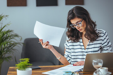 Worried and desperate woman banking and accounting home monthly and credit card expenses with...