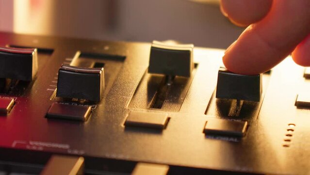 Midi keys on the table with neon lights. Closeup of male hands composing music using midi controller