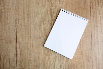 Obraz na płótnie Canvas checkered notepad on a wooden table, free space
