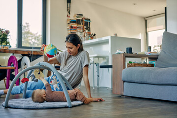 Mother sitting beside son who is playing with toys
