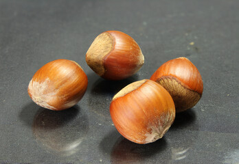 four hazelnuts on a glass table