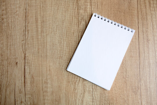 checkered notepad on a wooden table, free space