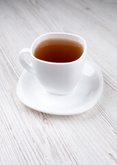 Tea in a white cup on a wooden table