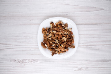Walnuts on a white plate. A plate of nuts on the table. Healthy food. Man's health.