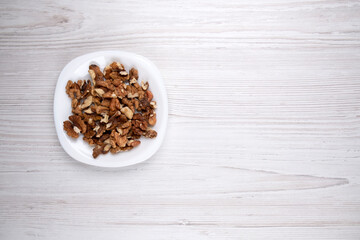 Walnuts on a white plate, free space. A plate of nuts on the table. Healthy food. Man's health. Healthy food