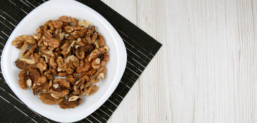 Walnuts on a black plate, on a black napkin. Healthy food