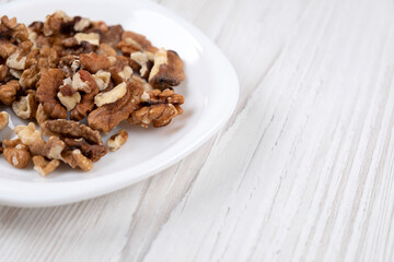 Plate with walnuts, close-up. Walnuts on a wooden table. Healthy food. Man's health.