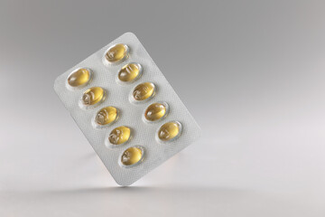 Blister with yellow jelly tablets, fish oil, daily dose of meds for person, pills in plastic package